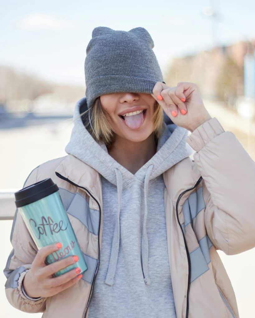 A girl holding a tumbler smiling